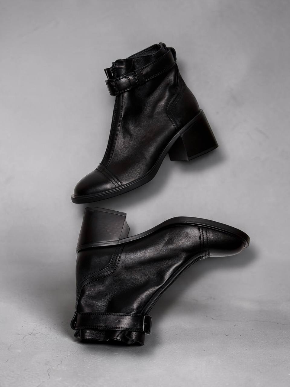 Side profile of black leather ankle boots Rider with block heels