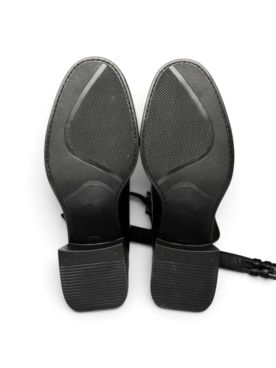 Black leather ankle boots featuring buckle straps and sculptural heels