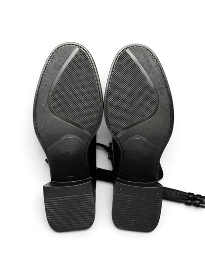 Black leather ankle boots featuring buckle straps and sculptural heels