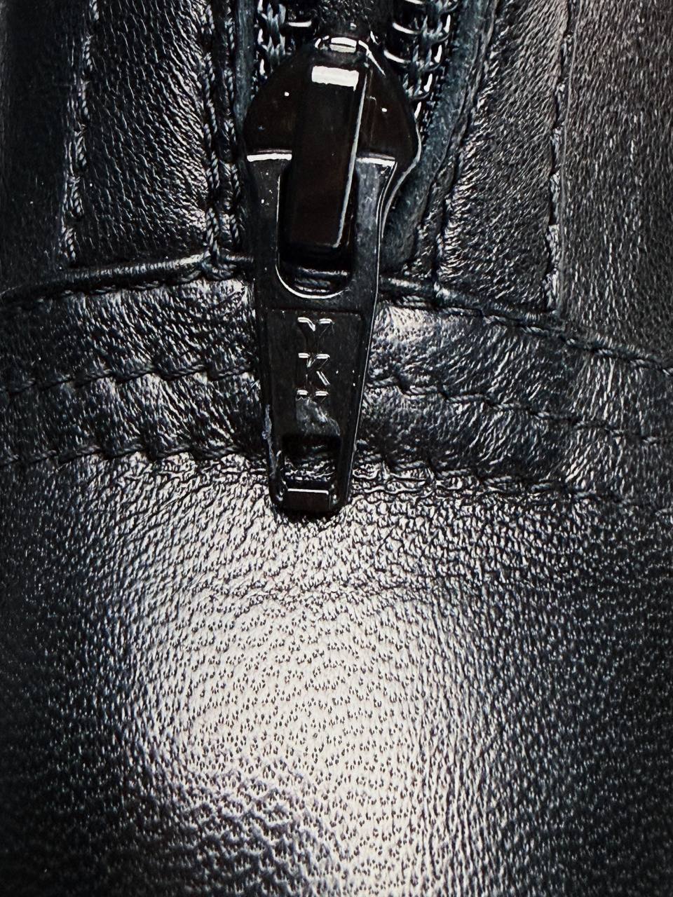 Close-up of zipper hardware on black leather boots