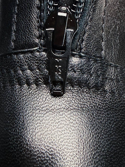Close-up of zipper hardware on black leather boots