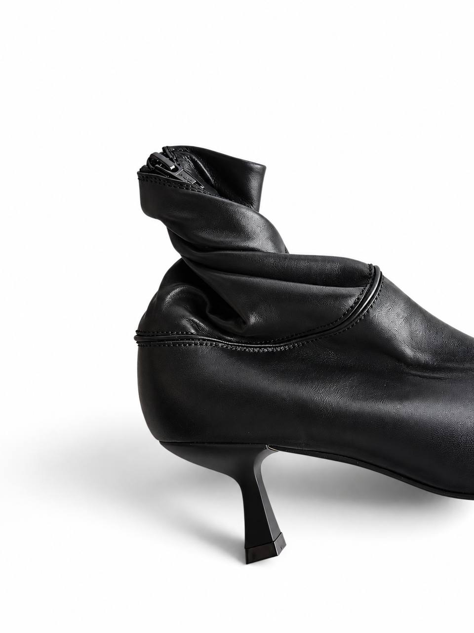 Sculpted 5 cm heel and curved stitching on black leather boots