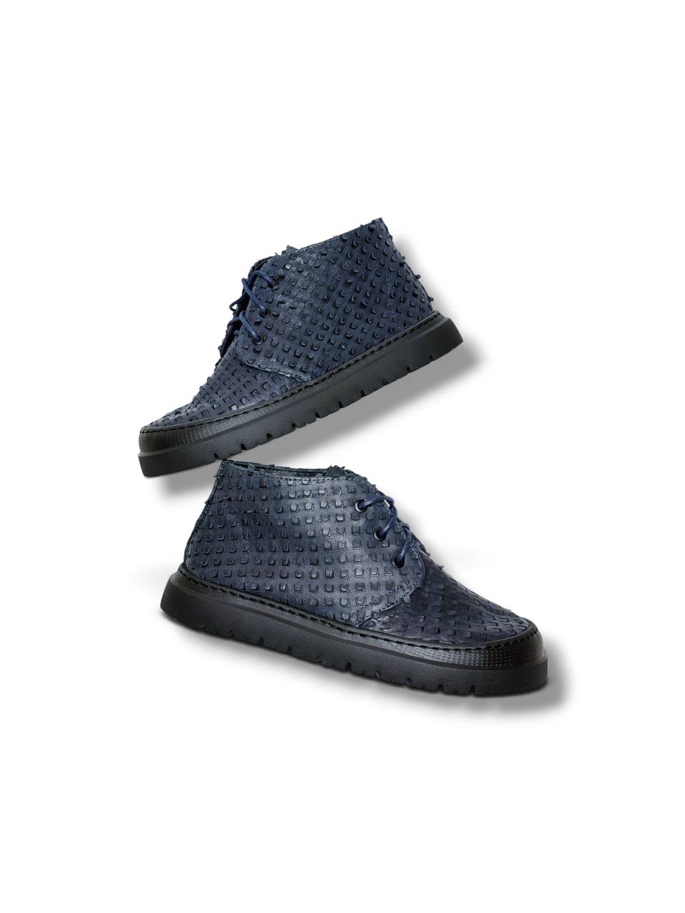 Angled view of textured blue desert boots with dark laces.