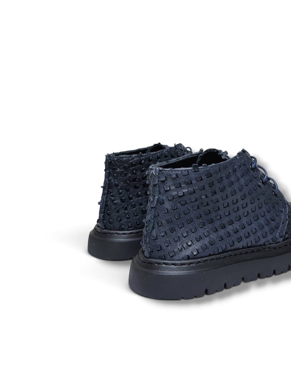 Rear view highlighting textured leather panels and chunky black soles.