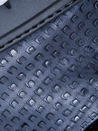 Close-up of textured navy leather showing the distinctive raised pattern.