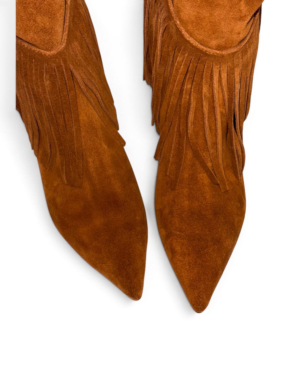 Close-up of pointed brown suede boots with long fringe