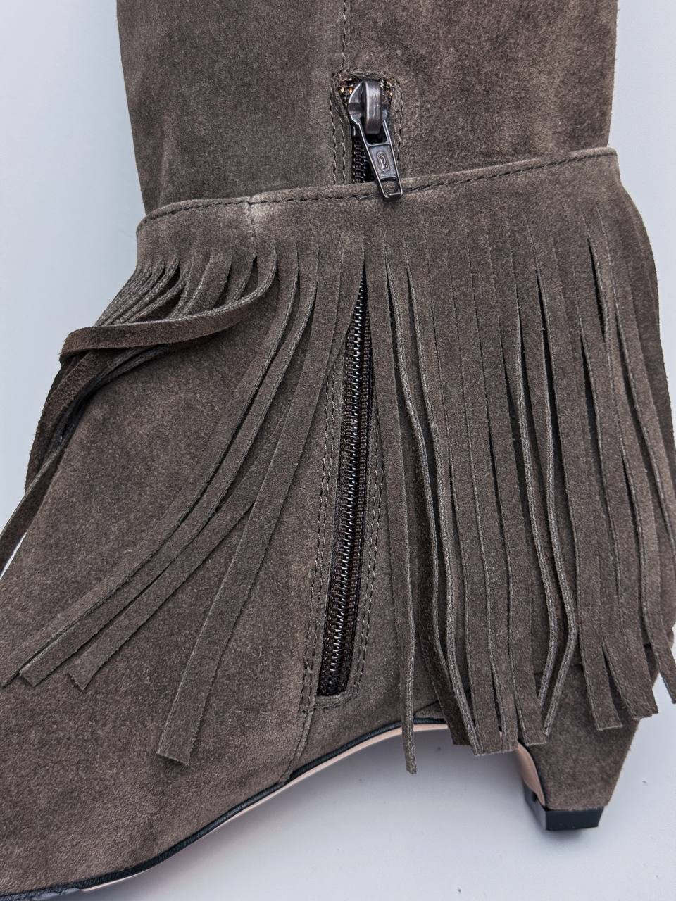 Removable suede fringe beside the side zipper on tall boots