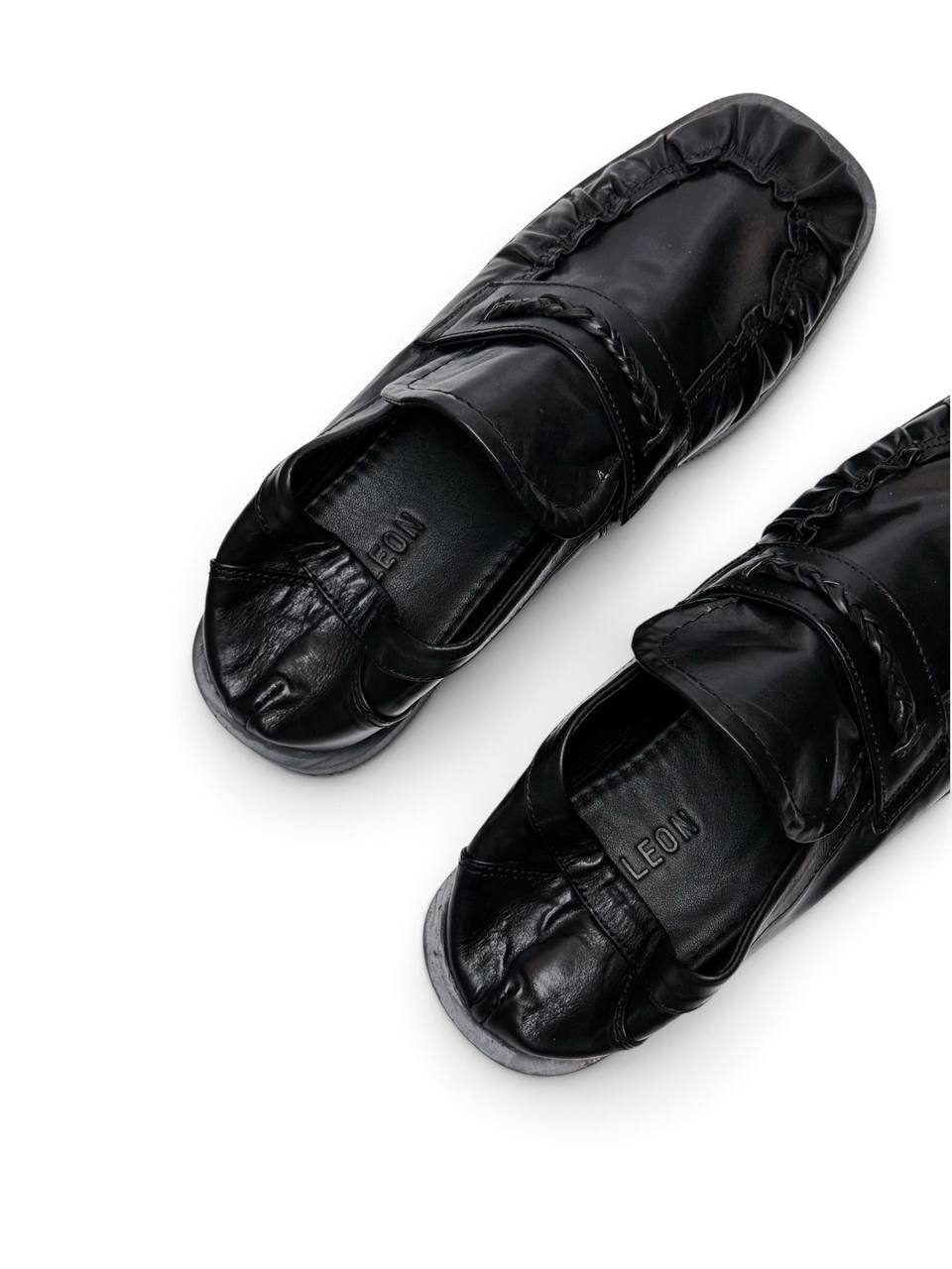 Black leather loafers viewed from above with branded insole and ruched toe