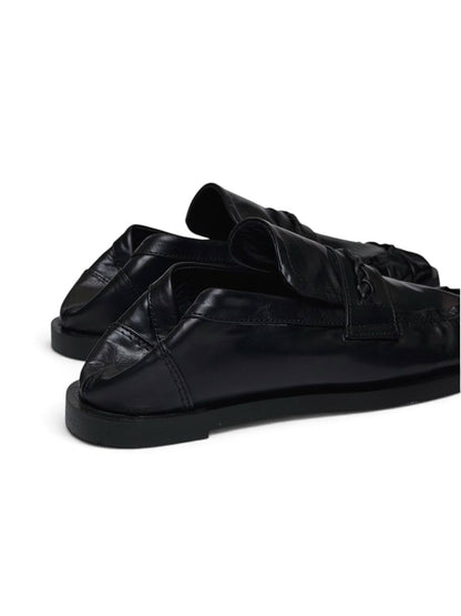 Black leather loafers in side profile with a low heel and ruched toe