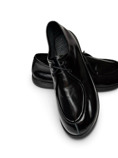 Close-up of black leather Onyx Walker shoe showing apron toe and lacing.