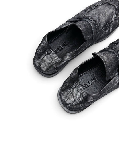 Close-up of gathered leather toe and woven detail on loafers Harry