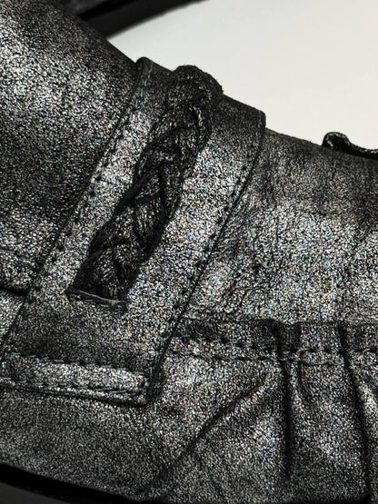 Close-up showing metallic leather texture and hand-finished stitching on loafers Harry