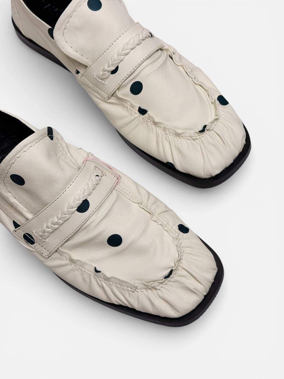 Close-up of gathered leather and braided strap detail