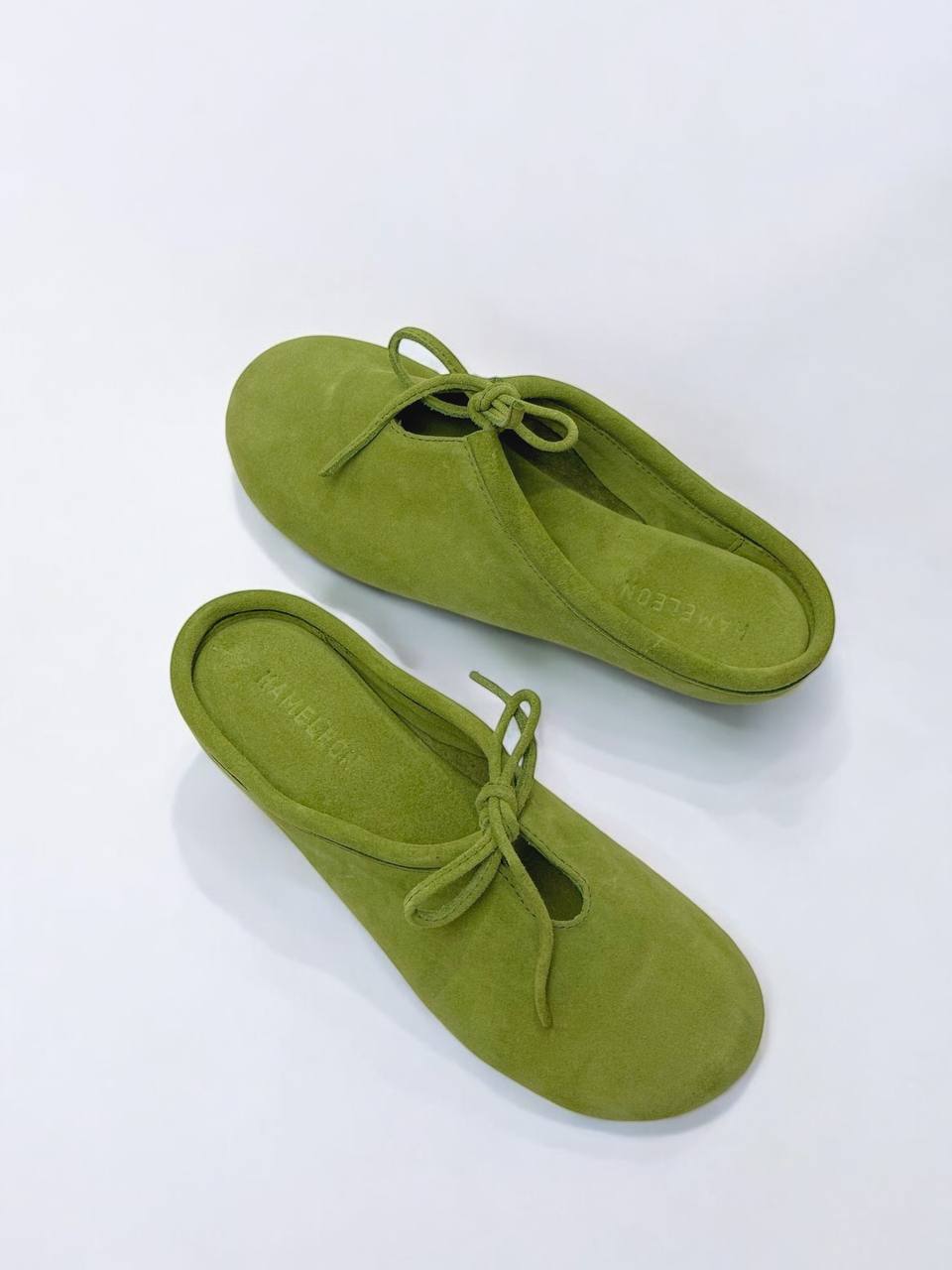 Top view of handmade LULU Moss suede mules with bow detail