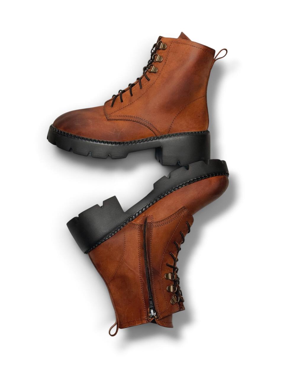 Side view of cognac leather boots with zipper closure.