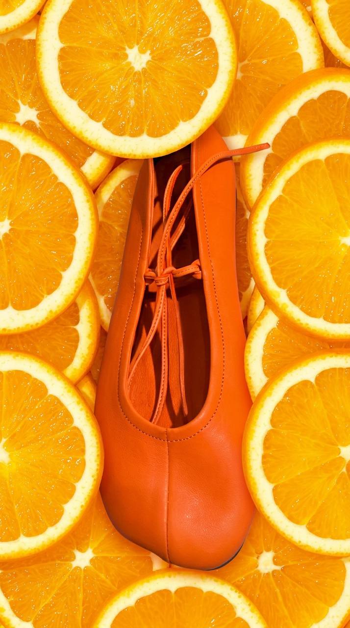 Orange Valencia leather ballet flats styled among fresh orange slices
