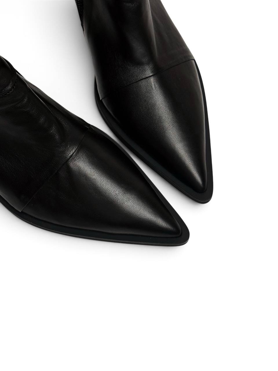 Pointed toes and smooth leather on black Western ankle boots